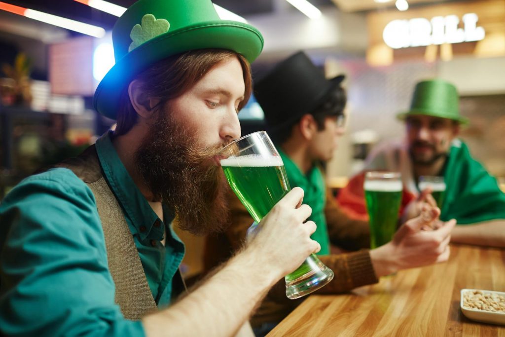 Man in Green Shirt Drinking Green Beer